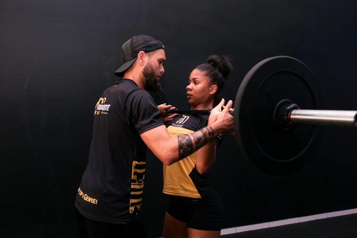 Mateus Andrade corrigindo o movimento de uma aluna no estúdio