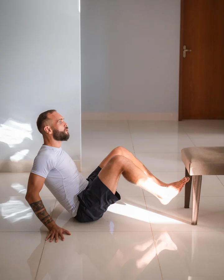 Mateus Andrade fazendo um treino com o peso do corpo na sala de casa